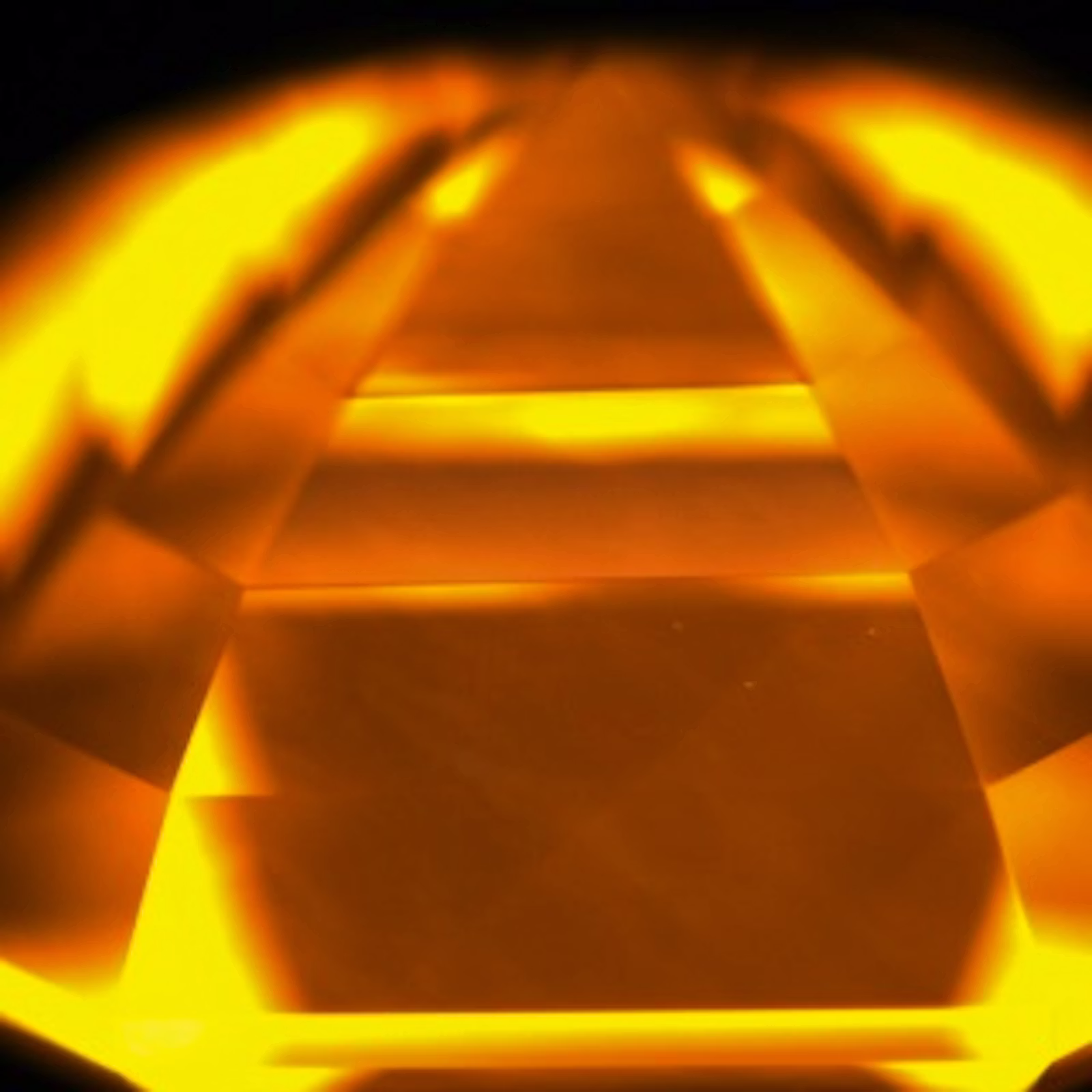 A close-up image of a diamond with an orange light shining through it.